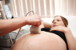 Doctor performing an ultrasound scan on pregnant woman Doctor performing an ultrasound scan on pregnant woman