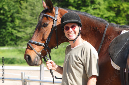 Foto: Mann mit Pferd fertig zum Ausritt Mann mit Pferd fertig zum Ausritt