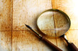 pen and magnifier  on old textured paper