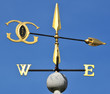 Foto: Golden wind vane against a clear blue sky Golden wind vane against a clear blue sky