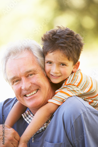 Photo: Grandfather Giving Grandson Ride On Back In Park Grandfather Giving Grandson Ride On Back In Park