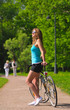 woman with bicycle in park