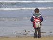 Niño con mochila en la playa