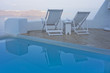 Swimming pool and deck chairs with sea view