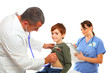 Male Doctor and female nurse examing a boy