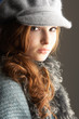 Fashionable Teenage Girl Wearing Cap And Knitwear In Studio