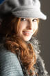 Fashionable Teenage Girl Wearing Cap And Knitwear In Studio