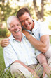 Senior Man With Adult Son In Garden