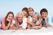 Photo: Three Generation Family Relaxing On Beach Holiday Three Generation Family Relaxing On Beach Holiday
