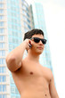 Attractive nude fit young businessman using a cell phone