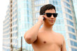 Attractive nude fit young businessman using a cell phone