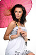 Thoughtful young woman sitting with pink umbrella