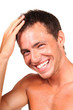 Closeup of a happy young man touching his hair