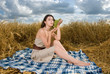 Beautiful slavonic girl on picnic in wheat field with grapes