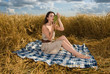 Beautiful slavonic girl on picnic in wheat field with grapes