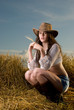 Beautiful slavonic girl in cowboy clothes pose in wheat field
