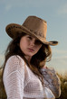 Beautiful slavonic girl in cowboy clothes pose in wheat field