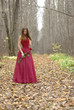 girl with a rose standing in the forest