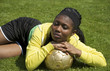 Junge Afrikanerin liegend mit goldenem Fussball