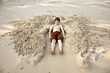 boy  is lying in a sandy bed at the beautiful beach