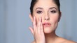 Beautiful young woman applaying cosmetics