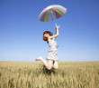 red-haired girl with umbrella at wheat field