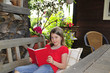Kind liest auf Terrasse Buch