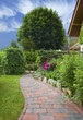 Garten mit Blumenbeet und Gartenweg eines Einfamilienhauses