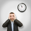 scared businessman and clock behind