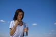girl holding a bottle of water against blue sky girl holding a bottle of water against blue sky