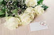 The invitation to wedding. A bunch of flowers and wedding rings