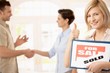Happy woman with for sale sign