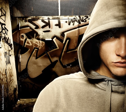 Photo: Cool looking hooligan in a graffiti painted gateway Cool looking hooligan in a graffiti painted gateway