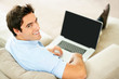 Relaxed young guy using laptop at home