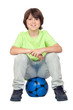 Adorable child sitting on blue soccer ball
