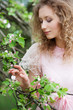 woman looking at small flower