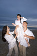 Photo: Hispanic family with daughter having fun on beach Hispanic family with daughter having fun on beach