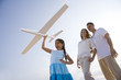 Photo: Hispanic family and girl having fun with toy plane Hispanic family and girl having fun with toy plane