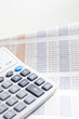 Calculator on top of newspaper with $ figurer amounts