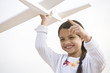 Photo: Smiling Hispanic girl playing with toy model plane Smiling Hispanic girl playing with toy model plane