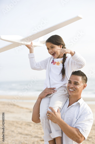 Photo: Hispanic father and daughter having fun on beach Hispanic father and daughter having fun on beach