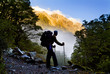 A hiker pauses for a rest at a clearing on Milford Track, NZ.