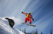 Snowboarder jumping through air with  blue sky in background