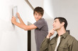Teenager hanging a picture on the wall