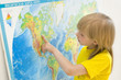 A girl looks at the world map