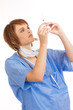 Foto: Young female nurse checking filled syringe Young female nurse checking filled syringe