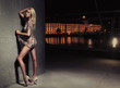 Sexy young blonde beauty posing over night city background