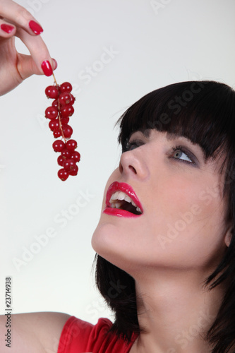 Foto: Portrait d'une femme mangeant des groseilles Portrait d'une femme mangeant des groseilles