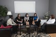 A Group Of People Talking In A Living Room