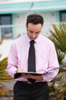 Young business man writing on clipboard
